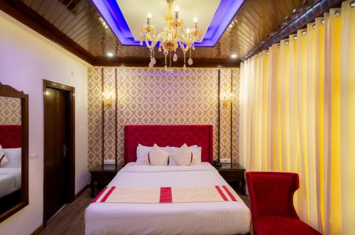 a bedroom with a bed and a chandelier at The Highland Park - A Truly River side Resort in Manāli