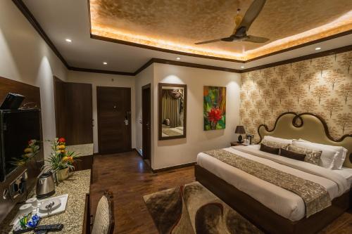 a bedroom with a bed and a ceiling at The Highland Park - A Truly River side Resort in Manāli