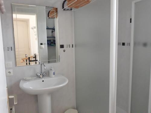 a white bathroom with a sink and a mirror at Chambres d'Hotes Elvire et Laurent Barbey in Sainte-Marie-du-Mont