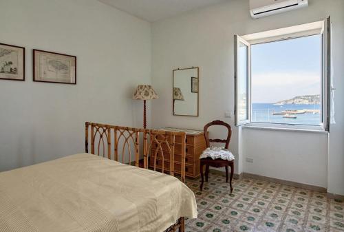 Schlafzimmer mit einem Bett und einem Fenster in der Unterkunft Il Torrione sul mare G1 in Ischia