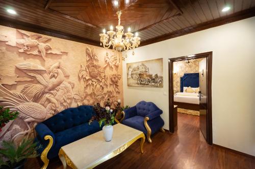a living room with blue couches and a painting on the wall at The Highland Park - A Truly River side Resort in Manāli