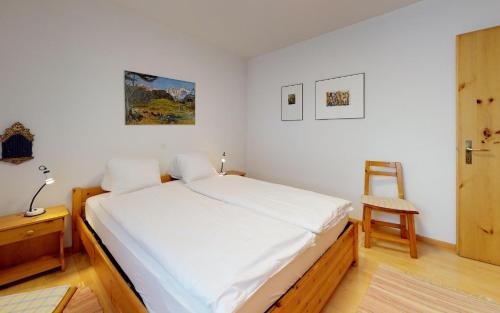 サンモリッツにあるPark Salet B18のベッドルーム(大きな白いベッド1台、椅子付)