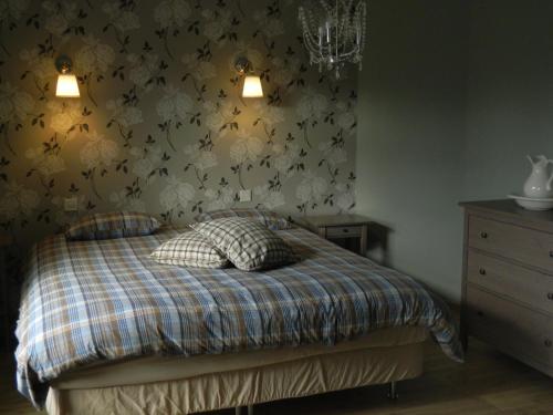 a bedroom with a bed with a floral wallpaper at B&B Les Tchéous in La Gleize