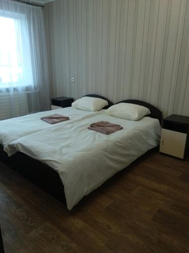 a bedroom with a large bed with two towels on it at Проспект Незалежності 48 City Rooms in Bila Tserkva