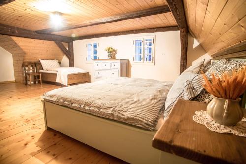 a bedroom with a large bed and a table at Chalupa u Studánky in Spálené
