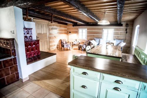 a kitchen with white cabinets and a living room at Chalupa u Studánky in Spálené