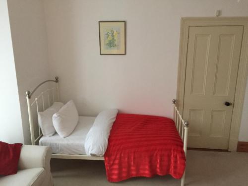 a bedroom with a white bed with a red blanket at Brackfield House Deal 49 in Killaloo