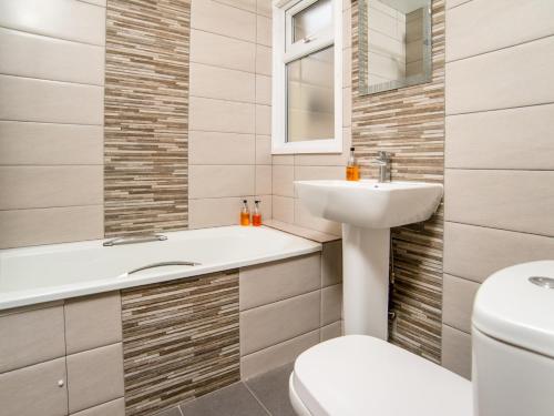a bathroom with a sink, toilet and bathtub at Padarn Hotel in Llanberis