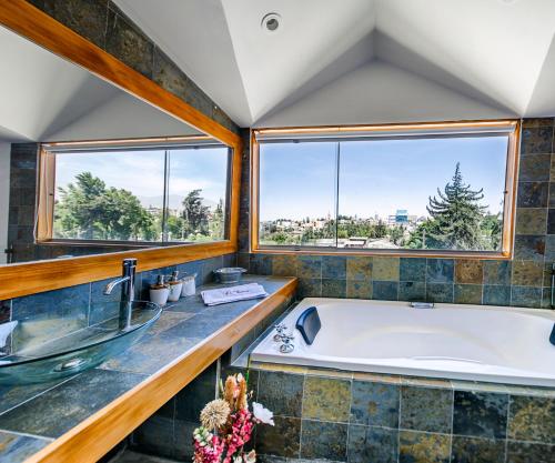 a large bathroom with a tub and two windows at La Hostería Boutique Hotel in Arequipa