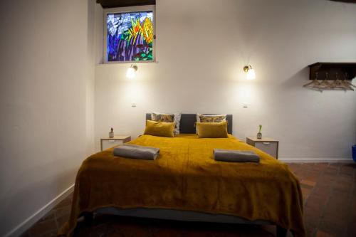 a bedroom with a large bed with a yellow blanket at Luxury Suites Riverside Residence by Rikas Hotels in Antwerp