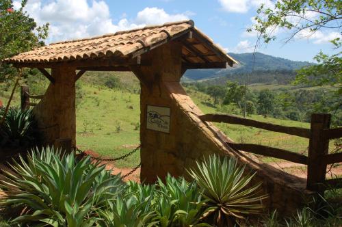a small wooden structure with a fence and a field at Chalés de Minas Hotel Fazenda in Caxambu