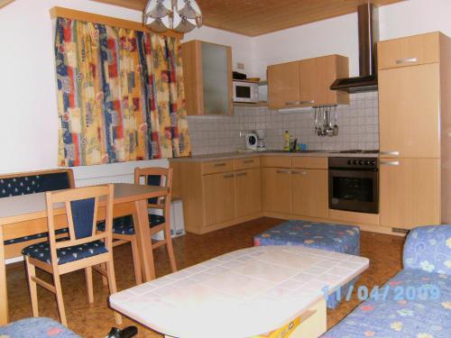 eine Küche mit einem Tisch und Stühlen sowie ein Esszimmer in der Unterkunft Ferienwohnung A 55 m2 in Lachtal