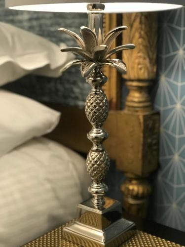 a metal pineapple candle stick on a table at The Somerville in Torquay