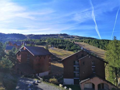 un groupe de bâtiments avec une montagne en arrière-plan dans l'établissement Les Chalets d'Aurouze, La joue du loup, à Saint-Étienne-en-Dévoluy