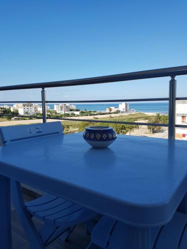 une table bleue avec un bol assis au-dessus dans l'établissement The Pearl Apartment Hammam Sousse WIFI, à Sousse