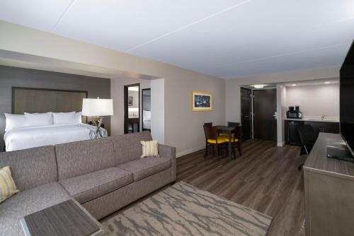 um quarto de hotel com um sofá e uma cama em La Quinta by Wyndham Raleigh Downtown North em Raleigh