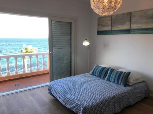 a bedroom with a bed and a balcony with the ocean at Blue relax Candelaria in Candelaria