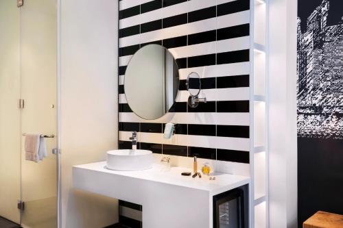 y baño con lavabo blanco y espejo. en ibis Styles Dubai Airport Hotel, en Dubái