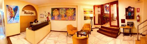 a living room with paintings on the walls at Hostal Macambo in Iquitos