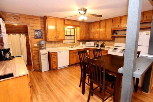 a kitchen with wooden cabinets and a table and chairs at Rio Lodge on The Guad in Second Crossing