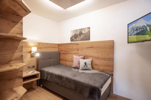 a small bedroom with a bed and a tv at otto steiner appartements pension ellmau & wilder kaiser in Ellmau