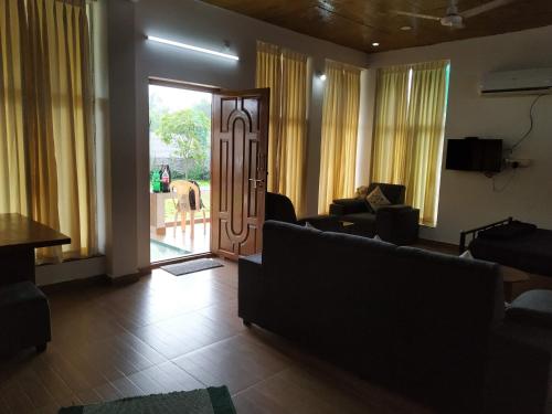 a living room with couches and a sliding glass door at Waves Beach House in Puducherry
