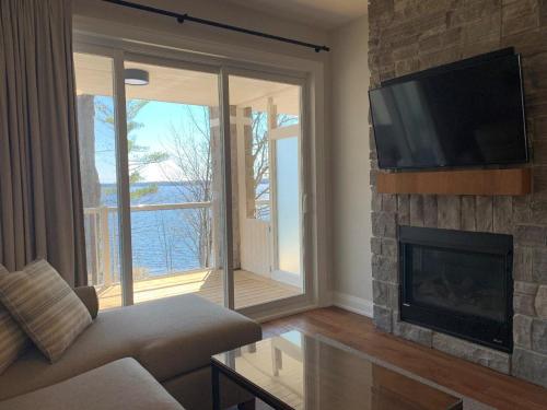 a living room with a fireplace and a television at Touchstone Resort in Bracebridge