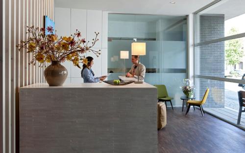 two men sitting at a counter in a room at Holiday Inn Express Mechelen City Centre by IHG in Mechelen