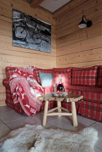 a living room with a red couch and a table at Domki nad jeziorem Widokowo in Reszel