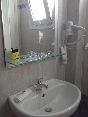 a white sink in a bathroom with a mirror at Kiklamino Sunset Studios in Oia