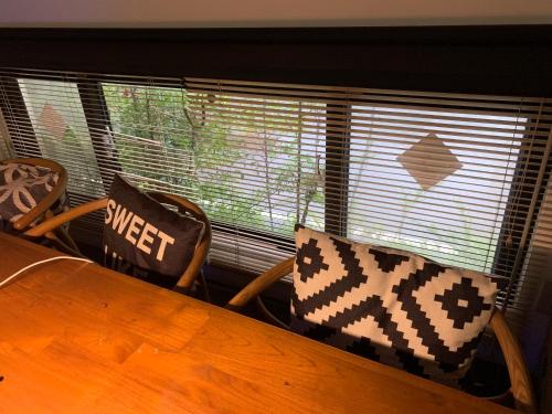 a dining room table with two chairs and a window at 幸福客棧 in Ho-mei