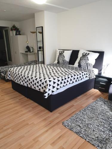a bedroom with a bed with a black and white comforter at DM Apartment in Triberg