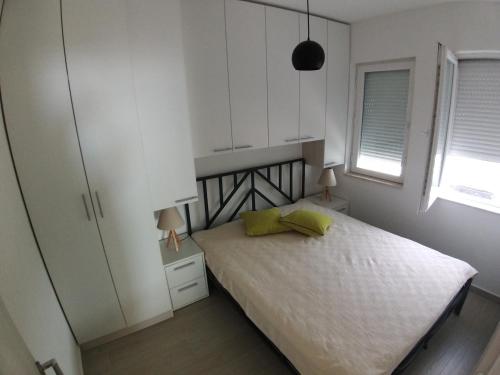 a bedroom with a bed and white cabinets at Apartman Dajoda 1 in Bijela