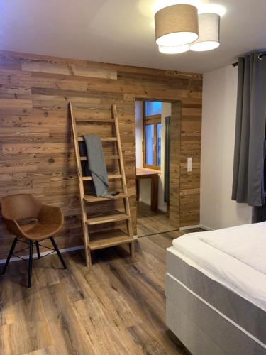 a bedroom with a bed and a wooden wall at Stadtvilla mit Pool in Jestetten