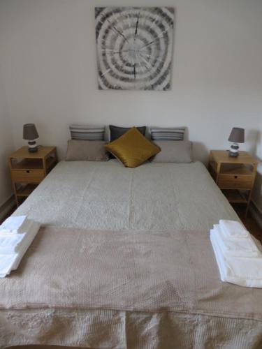 ein Schlafzimmer mit einem großen Bett mit einer Uhr an der Wand in der Unterkunft Alvalade Inn in Lissabon