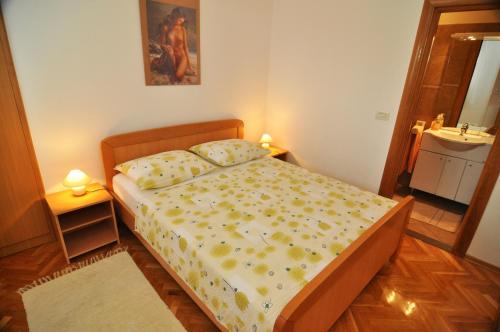 małą sypialnię z łóżkiem i umywalką w obiekcie Apartmani Rokić w mieście Seget Vranjica