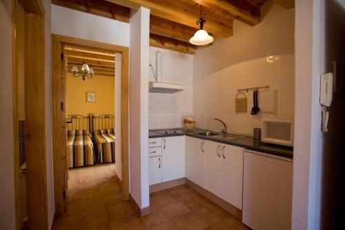 Una cocina con gabinetes blancos y un fregadero. en El Rincón de Uña, en Uña
