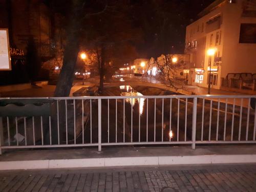 a city street at night with a fence at Apartament centrum Sienkiewicza WIEŻA EIFFLA PROMENADA -KLIMATYZACJA- WYJĄTKOWY in Kielce