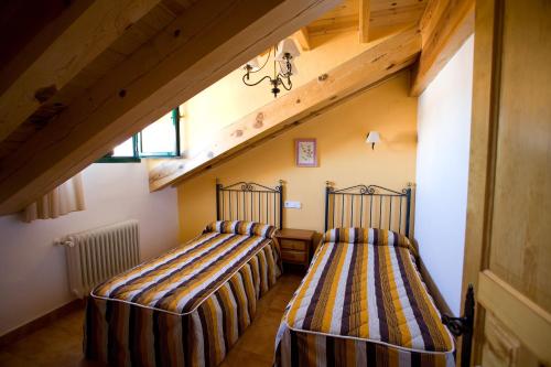 two beds in a room with an attic at El Rincón de Uña in Uña