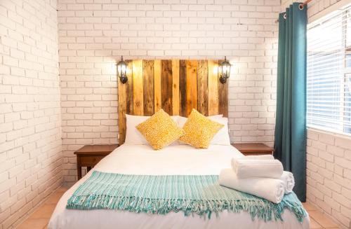 a bedroom with a large bed with a wooden headboard at Rozelee Rest 1 in Nelspruit