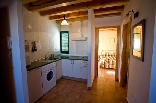 a kitchen with a sink and a washing machine at El Rincón de Uña in Uña