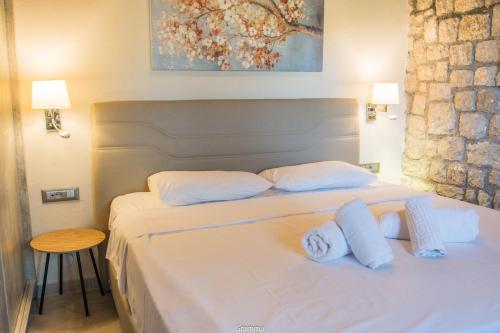 a bedroom with a bed with white sheets and towels at Villa Sealine in Pefki Rhodes