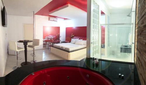 Habitación con baño con bañera roja. en Motel Anonimus, en Passo Fundo