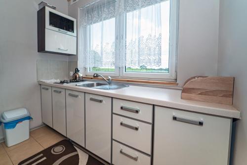 a kitchen with a sink and a window at Domek VICTORIA in Giżycko