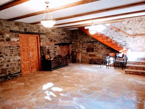 an empty room with a staircase and a stone wall at CastleHouse in Elbasan