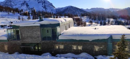 a building with snow on top of it at Teleo Vacanze - Villaggio Olimpico di Sestriere in Sestriere