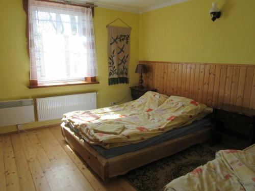 sypialnia z łóżkiem i oknem w obiekcie Chata na końcu świata w mieście Żytkiejmy