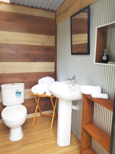 a bathroom with a toilet and a sink at The Primrose at Paradise Valley Glamping in Kerikeri
