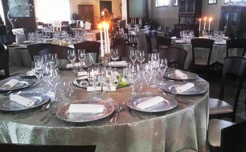 a dining room table filled with plates and wine glasses at Relais Casa Orter in Risano