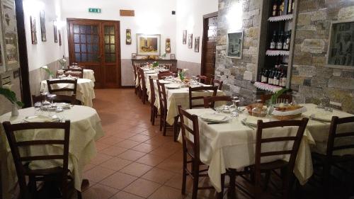 a row of tables in a restaurant with white table cloth at Il Falco E La Volpe in Settimo Vittone